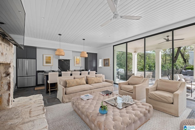 living area with ceiling fan, wooden ceiling, and stone finish floor