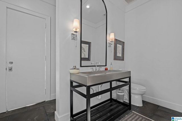 bathroom with vanity, toilet, and baseboards