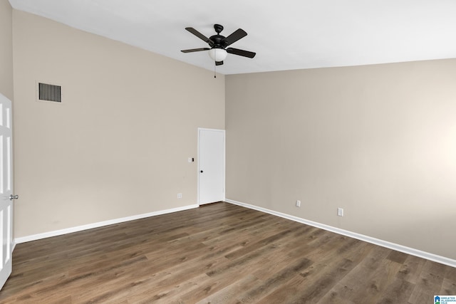 spare room featuring wood finished floors, visible vents, ceiling fan, and baseboards