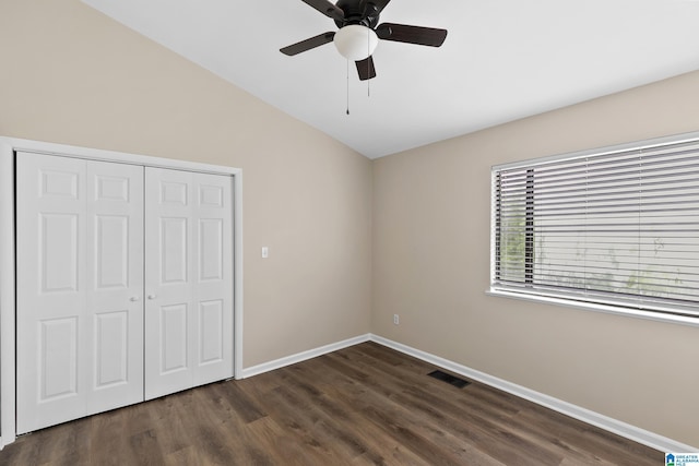 unfurnished bedroom with visible vents, vaulted ceiling, wood finished floors, and baseboards