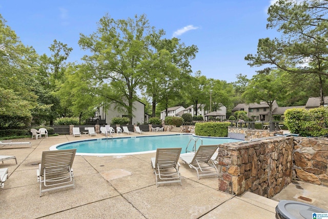 pool with a patio and fence