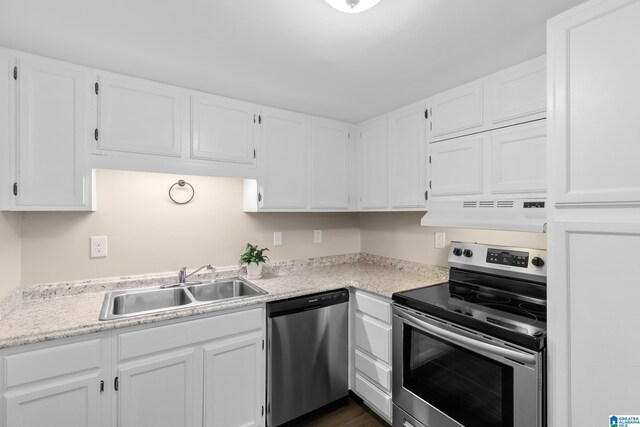 kitchen with a sink, white cabinets, stainless steel appliances, and under cabinet range hood