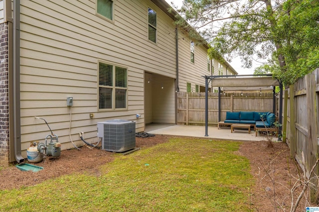 view of yard featuring a patio, an outdoor living space, a fenced backyard, and central AC