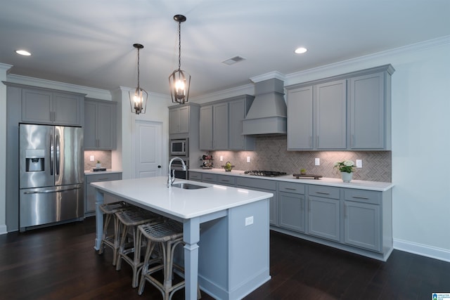 kitchen with a sink, custom exhaust hood, visible vents, gray cabinetry, and appliances with stainless steel finishes