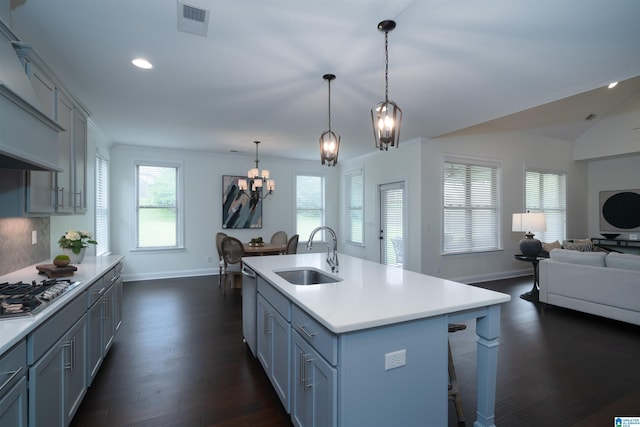 kitchen with a sink, a chandelier, stainless steel appliances, baseboards, and open floor plan
