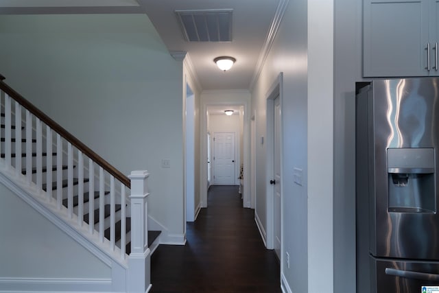 corridor featuring dark wood-style floors, crown molding, stairs, visible vents, and baseboards