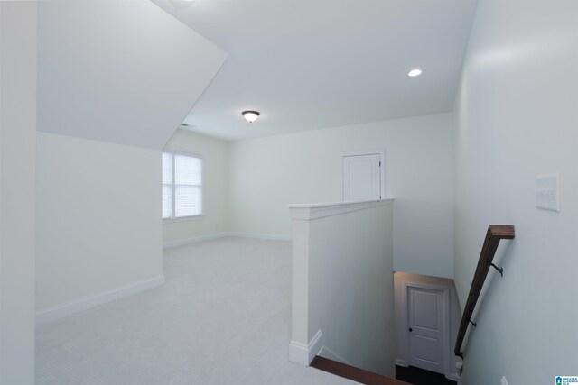 hallway featuring an upstairs landing, baseboards, recessed lighting, and carpet floors