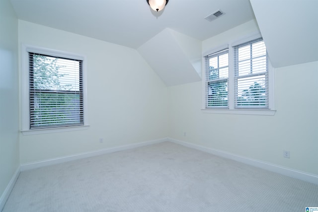 additional living space with baseboards, visible vents, carpet flooring, and vaulted ceiling