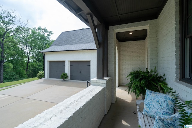 view of side of property with brick siding, roof with shingles, driveway, and an attached garage
