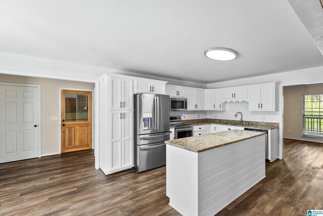 kitchen featuring a center island, a sink, appliances with stainless steel finishes, and dark wood-style flooring