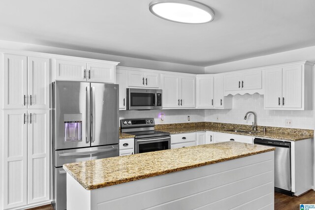 kitchen featuring white cabinetry, tasteful backsplash, stainless steel appliances, and a sink