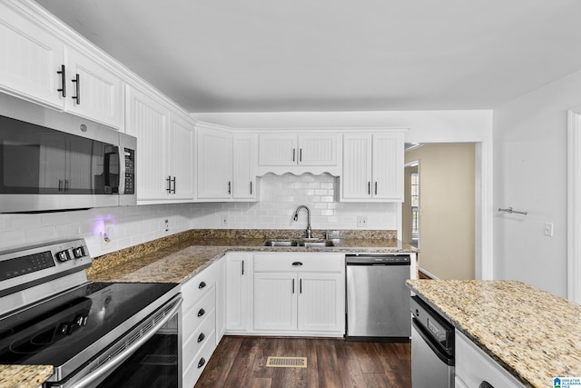 kitchen with white cabinets, a sink, visible vents, decorative backsplash, and appliances with stainless steel finishes