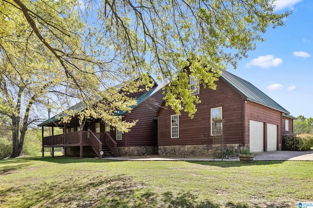 view of side of property featuring concrete driveway, a yard, stairs, and a garage