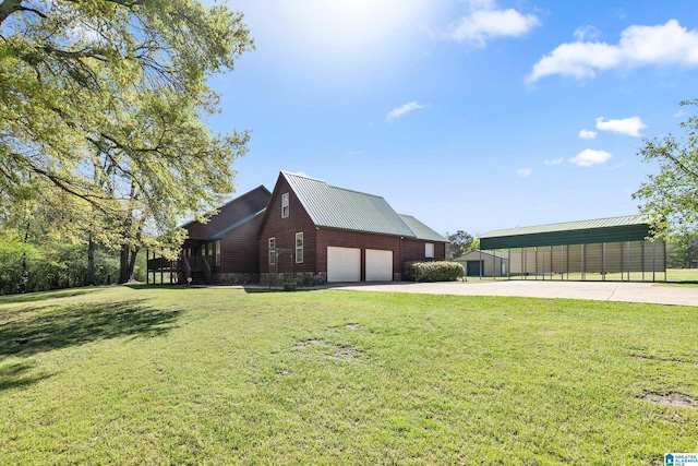 view of home's exterior featuring concrete driveway, metal roof, and a lawn