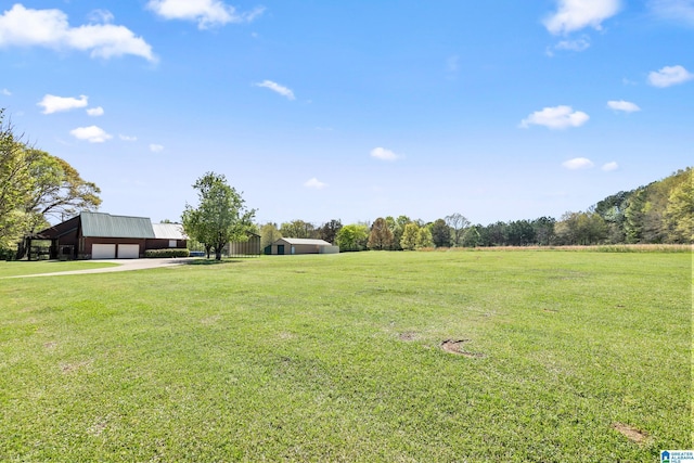 view of yard with driveway, an outbuilding, and a detached garage