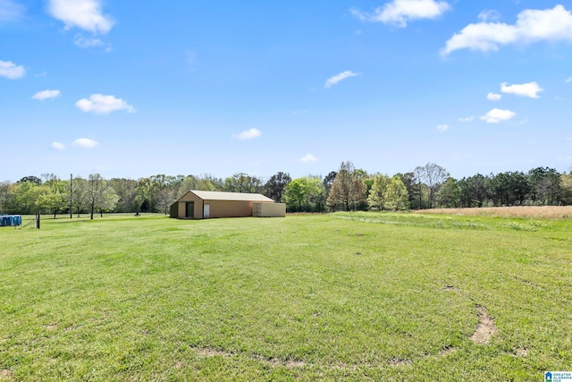 view of yard featuring a garage, a pole building, an outbuilding, and a rural view