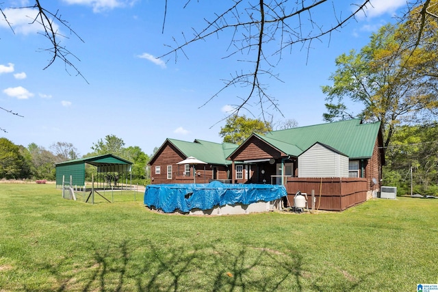 view of pool with central air condition unit, a lawn, fence, and a covered pool