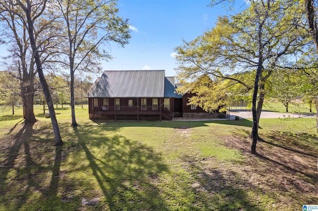 exterior space with covered porch, a yard, and metal roof