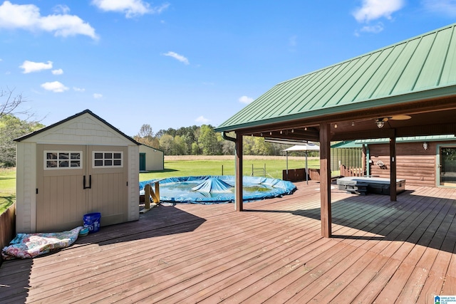 deck featuring a storage shed, an outbuilding, a covered pool, and a yard