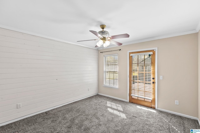 empty room featuring carpet floors, crown molding, baseboards, and ceiling fan