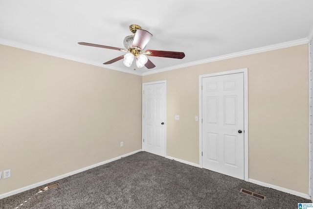unfurnished bedroom with dark carpet, visible vents, crown molding, baseboards, and ceiling fan
