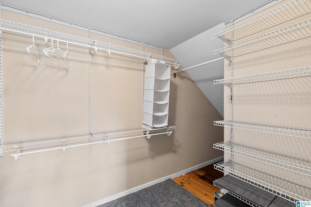 spacious closet with vaulted ceiling and wood finished floors