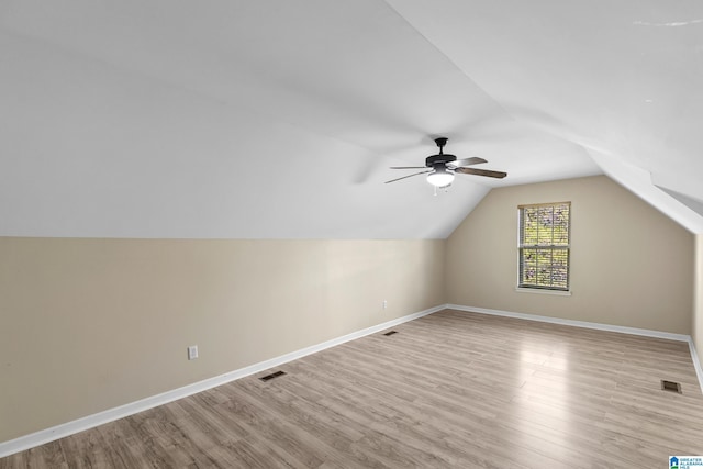 bonus room with vaulted ceiling, light wood-style floors, and visible vents