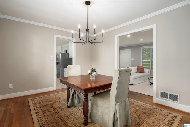 2005 Southwood Rd, Vestavia Hills, AL 35216 - dining room featuring an inviting chandelier, visible vents, baseboards, ornamental molding, and wood finished floors