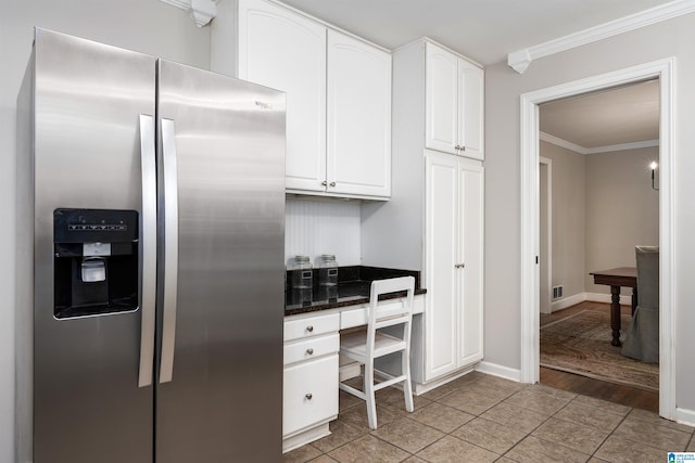 2005 Southwood Rd, Vestavia Hills, AL 35216 - kitchen with built in desk, light tile patterned floors, stainless steel fridge, crown molding, and white cabinetry