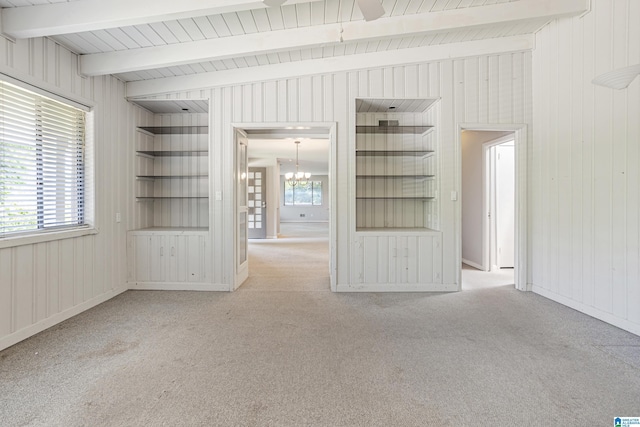 2725 Shades Crest Rd, Vestavia Hills, AL 35216 - unfurnished living room with built in shelves, wooden walls, carpet flooring, beamed ceiling, and a notable chandelier
