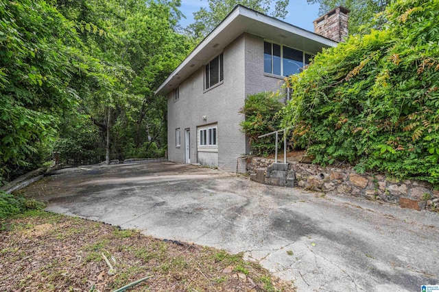2725 Shades Crest Rd, Vestavia Hills, AL 35216 - view of side of property with a patio, a chimney, and brick siding