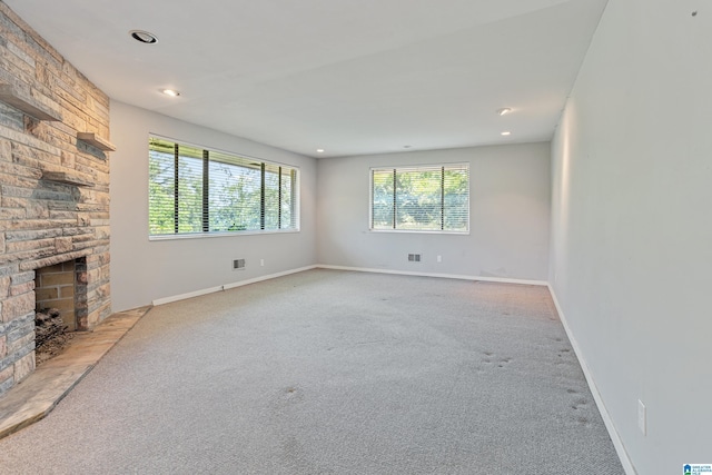 2725 Shades Crest Rd, Vestavia Hills, AL 35216 - unfurnished living room featuring baseboards, a stone fireplace, and light colored carpet