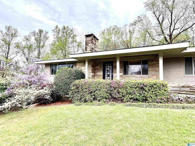 2725 Shades Crest Rd, Vestavia Hills, AL 35216 - view of front of house featuring stone siding, a chimney, and a front yard