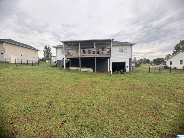 rear view of property with fence, a wooden deck, a lawn, and stairs