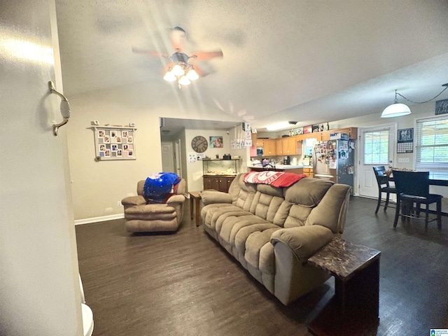 living room featuring baseboards, a ceiling fan, vaulted ceiling, and dark wood-style floors