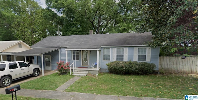 ranch-style home with a front yard, a carport, and fence