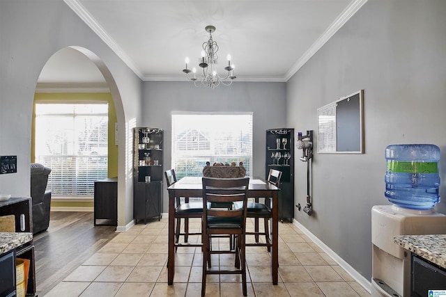 dining area with an inviting chandelier, ornamental molding, and a healthy amount of sunlight
