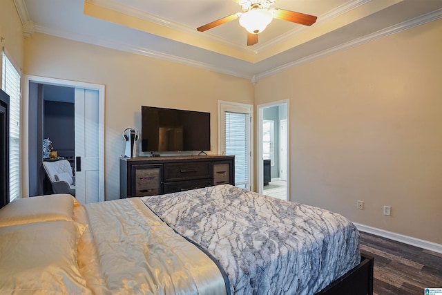 bedroom with a tray ceiling, baseboards, dark wood-style floors, and ornamental molding