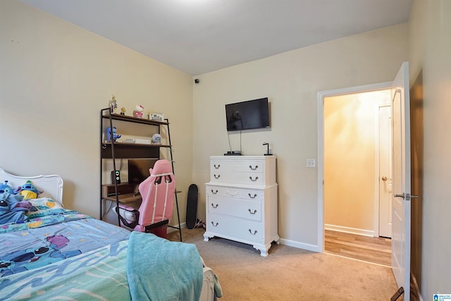 bedroom featuring light carpet and baseboards