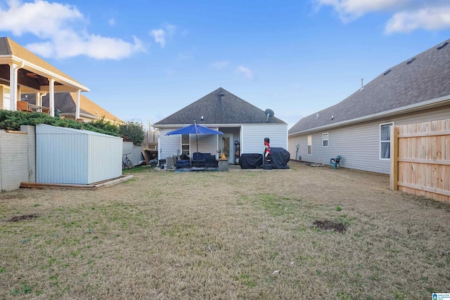 back of property with outdoor lounge area, a lawn, and fence