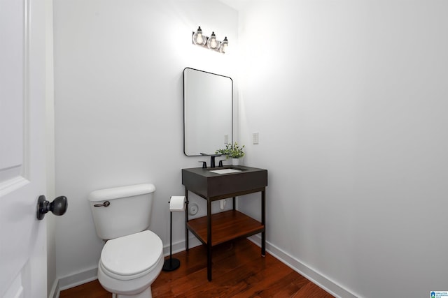2385 Village Center St, Hoover, AL 35226 - half bathroom featuring baseboards, toilet, a sink, and wood finished floors