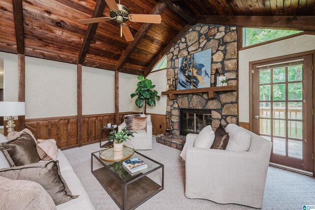 carpeted living area featuring a wainscoted wall, wood walls, vaulted ceiling with beams, wooden ceiling, and ceiling fan
