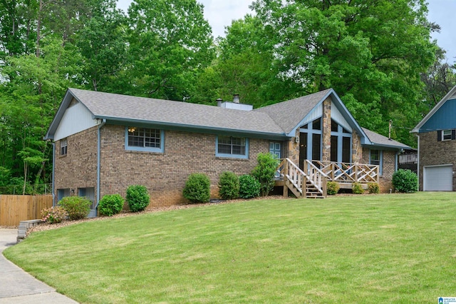 view of front of house featuring fence, a front lawn, and brick siding