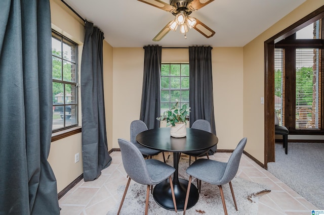 dining space with plenty of natural light, a ceiling fan, and baseboards