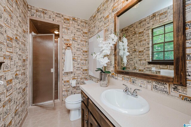 bathroom featuring wallpapered walls, tile patterned floors, toilet, vanity, and a stall shower