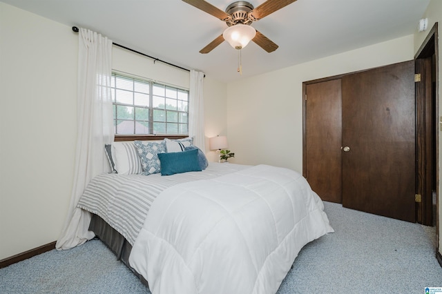 bedroom featuring a ceiling fan, a closet, and light colored carpet