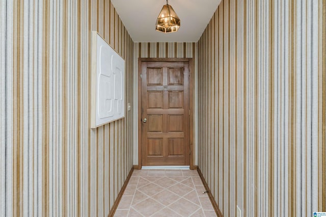 doorway to outside with baseboards and light tile patterned floors