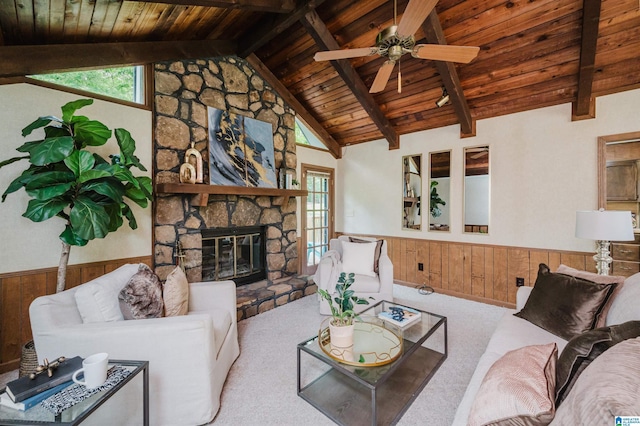 living room with a wainscoted wall, beam ceiling, a ceiling fan, wood ceiling, and wooden walls