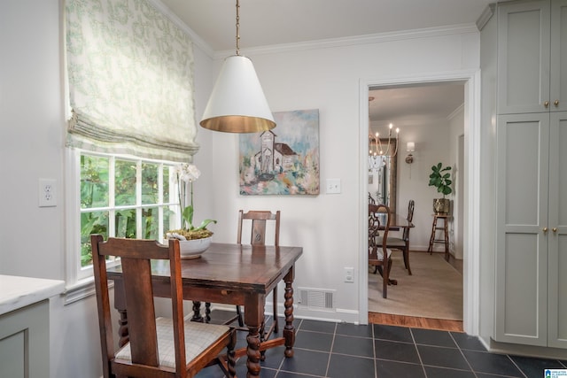 dining space with dark tile patterned flooring, baseboards, visible vents, a notable chandelier, and crown molding