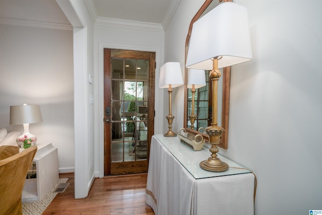 interior space with crown molding, wood finished floors, and baseboards